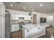 An open kitchen features stainless steel appliances, a center island with marble countertops, and hardwood floors at 6329 Sterling Ranch Way, North Las Vegas, NV 89081