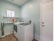Bright laundry room features modern washer and dryer units, plus shelving for storage and organization at 6329 Sterling Ranch Way, North Las Vegas, NV 89081