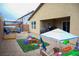 A cute backyard area with artificial turf, a patio cover, and a fun playground at 645 Turtleback Falls Ave, Indian Springs, NV 89018