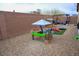 Cozy backyard area with a patio cover, a fire pit, and a fun playground at 645 Turtleback Falls Ave, Indian Springs, NV 89018