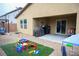 Backyard featuring a patio, grill, playset on artificial grass, and low-maintenance gravel landscaping at 645 Turtleback Falls Ave, Indian Springs, NV 89018