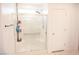 Modern bathroom featuring a clear glass-enclosed shower and white tiling with a convenient towel rack at 645 Turtleback Falls Ave, Indian Springs, NV 89018