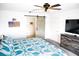 Relaxing bedroom showcases a blue patterned comforter, barn door access, and ceiling fan at 645 Turtleback Falls Ave, Indian Springs, NV 89018