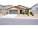 Inviting single-story home featuring low-maintenance landscaping, a gray two-car garage, and a neutral color palette at 645 Turtleback Falls Ave, Indian Springs, NV 89018