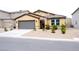 Charming single-story home with a tile roof, gravel yard, and a gray two-car garage at 645 Turtleback Falls Ave, Indian Springs, NV 89018