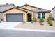 Inviting single-story home featuring low-maintenance landscaping, a gray two-car garage, and a neutral color palette at 645 Turtleback Falls Ave, Indian Springs, NV 89018