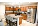 Stylish kitchen features an island with bar seating, stainless steel appliances, and wood cabinetry at 645 Turtleback Falls Ave, Indian Springs, NV 89018