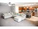 Open-concept living room and kitchen with a large sectional sofa and modern appliances at 645 Turtleback Falls Ave, Indian Springs, NV 89018