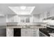 Bright kitchen with white cabinetry, granite countertops, and stainless steel appliances under a skylight at 6733 W Charleston Blvd # 3, Las Vegas, NV 89146