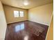 Bright bedroom features gleaming hardwood floors and natural light from two windows at 6778 Goose Watch Ct, Las Vegas, NV 89139
