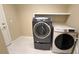 Functional laundry room featuring modern washer and dryer units and tile flooring at 6778 Goose Watch Ct, Las Vegas, NV 89139