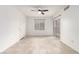 Bright living room showcasing ceramic tile floor, ceiling fan, and a sliding glass door to patio with black metal railing at 6868 Sky Pointe Dr # 1122, Las Vegas, NV 89131