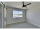 Bedroom features modern barn door, neutral carpet, and a window providing natural light at 709 Rossmoyne Ave, North Las Vegas, NV 89030