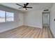 This bedroom features wood floors, a ceiling fan, and a bright window view at 709 Rossmoyne Ave, North Las Vegas, NV 89030