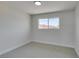Bright bedroom with neutral carpet, white trim, and a window at 709 Rossmoyne Ave, North Las Vegas, NV 89030