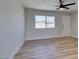 This bedroom has wood floors and is lit by a ceiling fan with a window view at 709 Rossmoyne Ave, North Las Vegas, NV 89030