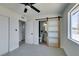 Bright bedroom featuring a sliding barn door leading to an en-suite bathroom at 709 Rossmoyne Ave, North Las Vegas, NV 89030