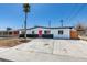 Charming single-story home showcasing a red front door, desert landscaping, and mature palm tree at 709 Rossmoyne Ave, North Las Vegas, NV 89030