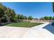 Spacious backyard with grass, retaining wall, basketball court, trampoline, and extended patio perfect for entertaining at 7360 Dolphine Crest Ave, Las Vegas, NV 89129