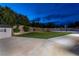 Night view of backyard featuring grass, mature landscaping, basketball court, and a storage shed at 7360 Dolphine Crest Ave, Las Vegas, NV 89129