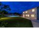 Two-story home featuring a spacious backyard with grass, basketball court, and covered patio at 7360 Dolphine Crest Ave, Las Vegas, NV 89129