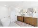 Luxurious bathroom with dual vanities, freestanding tub, marble floors, and modern fixtures at 7360 Dolphine Crest Ave, Las Vegas, NV 89129