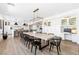 Dining area with long table, modern lighting, built-in cabinets and workspace looking into the kitchen at 7360 Dolphine Crest Ave, Las Vegas, NV 89129