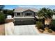 Charming two-story home featuring a three-car garage, desert landscaping, and a tile roof at 7360 Dolphine Crest Ave, Las Vegas, NV 89129