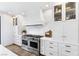 Gourmet kitchen featuring a large stainless steel range and hood with custom cabinetry and countertops at 7360 Dolphine Crest Ave, Las Vegas, NV 89129