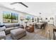 Bright, open-concept living room flows into dining area, featuring large windows and a modern design at 7360 Dolphine Crest Ave, Las Vegas, NV 89129