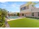 This backyard features a sparkling pool, green lawn, and modern architecture, perfect for outdoor living and entertaining at 7385 Heron Canyon Ct, Las Vegas, NV 89117