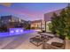 Luxurious backyard featuring a modern pool, waterfall feature, outdoor bar, and comfortable seating area at 7385 Heron Canyon Ct, Las Vegas, NV 89117