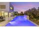 Inviting backyard with a sparkling pool, ample seating, lush landscaping, and modern architectural design at 7385 Heron Canyon Ct, Las Vegas, NV 89117