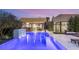 Tranquil backyard with a pool, outdoor dining area, lounge chairs, and a modern waterfall feature at 7385 Heron Canyon Ct, Las Vegas, NV 89117