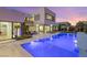 Stunning backyard oasis with a pool, lounge chairs, an outdoor kitchen, and beautifully landscaped grounds at 7385 Heron Canyon Ct, Las Vegas, NV 89117