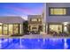 Inviting backyard features a sparkling pool, lounge area, and modern architecture under a beautiful sunset sky at 7385 Heron Canyon Ct, Las Vegas, NV 89117