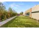 This backyard features a lush green lawn with manicured landscaping and a pathway that leads to a modern home at 7385 Heron Canyon Ct, Las Vegas, NV 89117