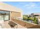 Balcony with minimalist seating overlooks the property's pool and landscaping, offering outdoor relaxation at 7385 Heron Canyon Ct, Las Vegas, NV 89117