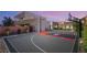 Backyard basketball court next to modern architecture featuring a red and black court and adjustable hoop at 7385 Heron Canyon Ct, Las Vegas, NV 89117