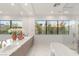 Bright and airy bathroom with dual sinks, modern fixtures, and large windows showcasing the landscaped yard at 7385 Heron Canyon Ct, Las Vegas, NV 89117