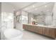 Luxurious bathroom featuring a soaking tub, double vanity, and large mirror at 7385 Heron Canyon Ct, Las Vegas, NV 89117