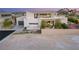 Modern house with a desert landscape, features a dark garage door, and is a stylish architectural design at 7385 Heron Canyon Ct, Las Vegas, NV 89117