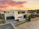 Stunning modern home featuring a three car garage, xeriscaped yard, and vibrant sunset backdrop at 7385 Heron Canyon Ct, Las Vegas, NV 89117