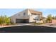 Contemporary home with a clean, modern facade, a three-car garage, and manicured landscaping for curb appeal at 7385 Heron Canyon Ct, Las Vegas, NV 89117