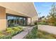 Modern home with expansive sliding glass doors leading from the indoors to the manicured landscape at 7385 Heron Canyon Ct, Las Vegas, NV 89117