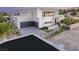 Modern two-story home with a gray garage door, landscaped front yard, and pathway leading to the front door at 7385 Heron Canyon Ct, Las Vegas, NV 89117