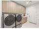 Well-organized laundry room with modern appliances, ample cabinet space and utility sink at 7385 Heron Canyon Ct, Las Vegas, NV 89117