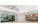 Elegant living room with high ceilings, a modern kitchen, and large windows providing stunning outdoor views at 7385 Heron Canyon Ct, Las Vegas, NV 89117