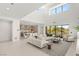 Bright, open-concept living room features modern decor, high ceilings, and abundant natural light from large windows at 7385 Heron Canyon Ct, Las Vegas, NV 89117