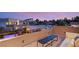 Spacious roof deck featuring sleek modern furniture, offering panoramic views of the surrounding neighborhood at sunset at 7385 Heron Canyon Ct, Las Vegas, NV 89117
